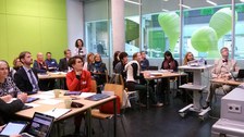 Bild eines Seminarraumes im Informatikgebäude der TU Dresden, in dem viele Menschen an verschiedenen Gruppentischen sitzen und augenscheinlich einem Vortrag zuhören.