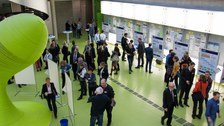 Bild des Foyers der Fakultät Informatik an der TU Dresden. Zu sehen sind mehrere Personen, die teilweise vor Informationstafeln stehen und sich diese augenscheinlich durchlesen.
