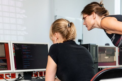 Eindrücke einer Fortbildungssituation. Eine Dozentin erklärt einer Teilnehmerin etwas an einem PC.