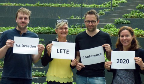 Foto von vier Personen, die jeweils ein Blatt Papier vor sich halten. Die aufschrift der vier Blätter ergibt zusammen den Text "1st Dresden LETE Conference 2020"