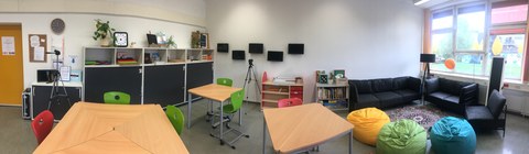 Panoramaansicht des Lehr-Lern-Raums Inklusion mit Tisch-Gruppen, Materialen und der Leseecke