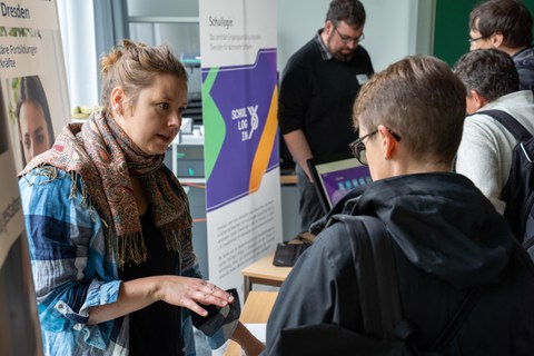 Frauen unterhalten sich in einem Raum wo buntes Treiben herrscht