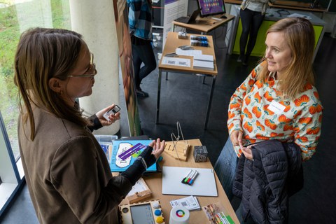 Zwei Frauen unterhalten sich und dabei sind Unterrichtsmaterialen für inklusiven Unterricht zu sehen