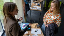 Zwei Frauen unterhalten sich und dabei sind Unterrichtsmaterialen für inklusiven Unterricht zu sehen