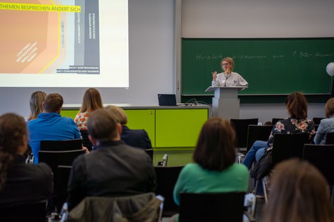 Frau hält Vortrag und steht dabei an einem Pult