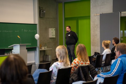 Mann hält Vortrag in einem Seminarraum.