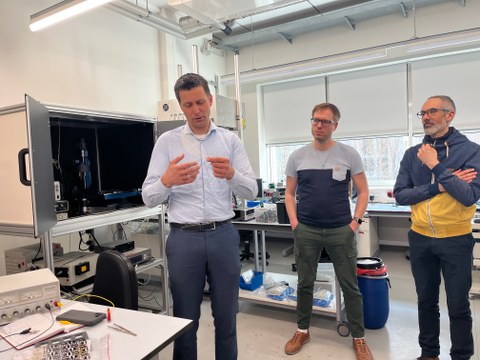 Mann erklärt etwas anschaulich in einem Physikalischen Labor