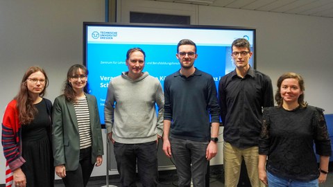 Gruppenfoto mit 6 Personen vor einem vor einem BIldschirm mit Titelfolie einer Präsentation