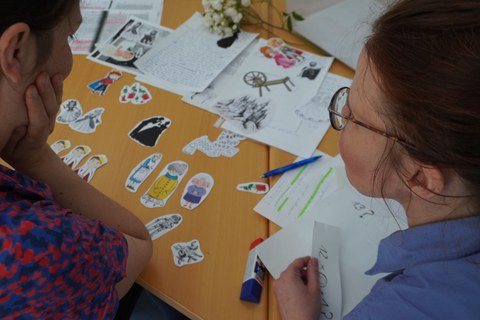 Zwei Frauen arbeiten an einem Tisch mit Legekärtchen