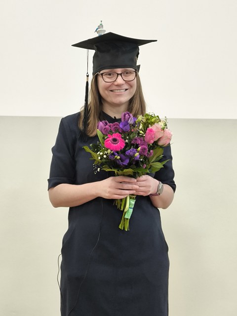 Frau mit Doktorhut und Straß Blumen
