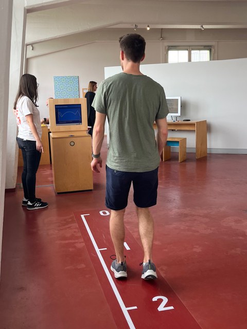 Mann geht in einem Museum an einer weißen Linie am Boden entlang