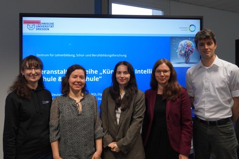 Gruppenbild mit fünf Personen vor der Startfolie einer Präsentation