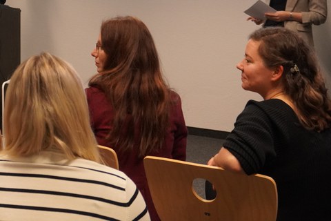 3 sitzende Frauen seitlich von hinten fotografiert.