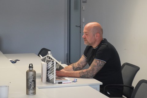 Mann liest aus einem Buch im Sizen vor