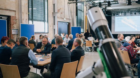 Mehrere Personen diskutieren an einem Tisch