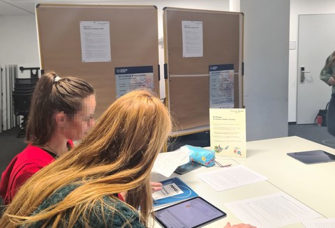 Zwei Frauen arbeiten zusammen an einem Tisch im Seminar
