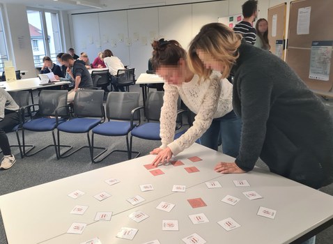 Zwei Frauen arbeiten zusammen an einem Tisch im Seminar