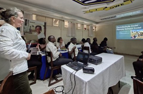Foto zeigt einen Seminarraum in Uganda, in dem gerade eine Präsentation gezeigt wird.