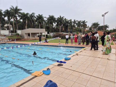 Foto eines Schwimmbeckens mit Personen, die am Rand stehen