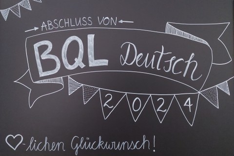 Eine Tafel beschrieben mit "BQL Deutsch"