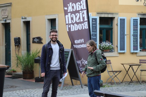 Mann und Frau stehen vor einem alten Haus.