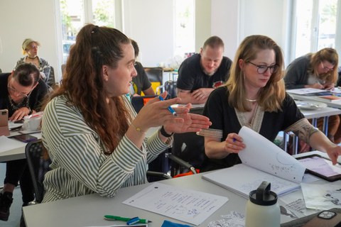 Zwei Frauen, die nebeneinander in einem Seminar sitzen. 