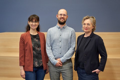 Gruppenbild mit zwei Frauen und einem Mann in der Mitte.