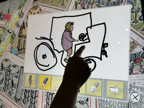 Bild einer Grafik auf einem Touchscreen, auf dem eine Person mit ihrem Finger etwas malt.