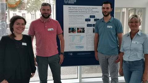 Auf dem Bild ist das Team von BQL.Digital zu sehen, das gemeinsam mit Dr. Peggy Germer ein wissenschaftliches Poster auf dem Workshop on E-Learning 2023 präsentiert. Das Poster trägt den Titel: "BQL.Digital: Unterstützung für digitales Lehren und Lernen" 