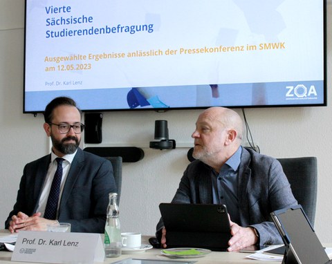 Prof. Dr. Karl Lenz und Staatsminister Sebastian Gemkow bei der Präsentation der Forschungsergebnisse vor einem Bildschirm, auf welchem steht: Vierte Sächsische Studierendenbefragung. Ausgewählte Ergebnisse anlässlich der Pressekonferenz im SMWK am 12.05.2023