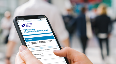 Close-up of hands holding a smartphone. The screen shows the online survey of students for quality in studies and teaching.